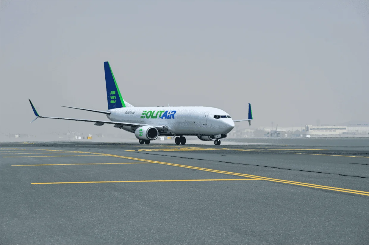 SolitAir航空货机停驻在跑道上，采用绿色和蓝色品牌色，专营中国到迪拜空运解决方案。